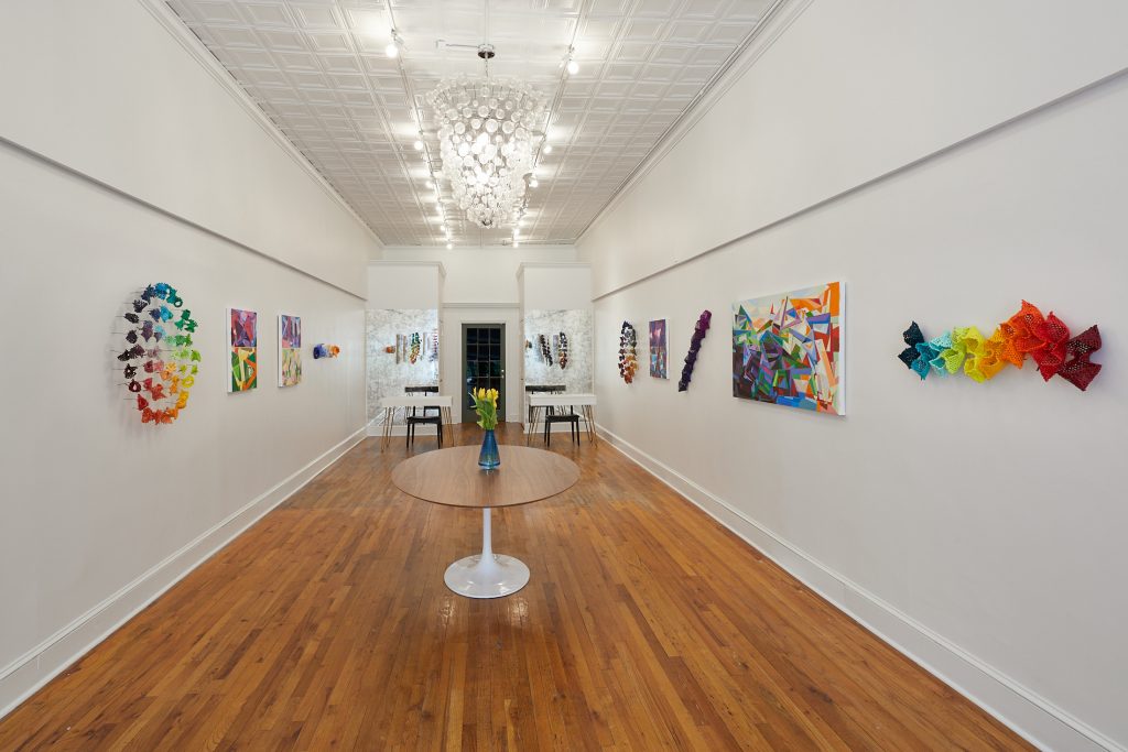 Gallery with colorful biomorphic sculptures and geometric paintings